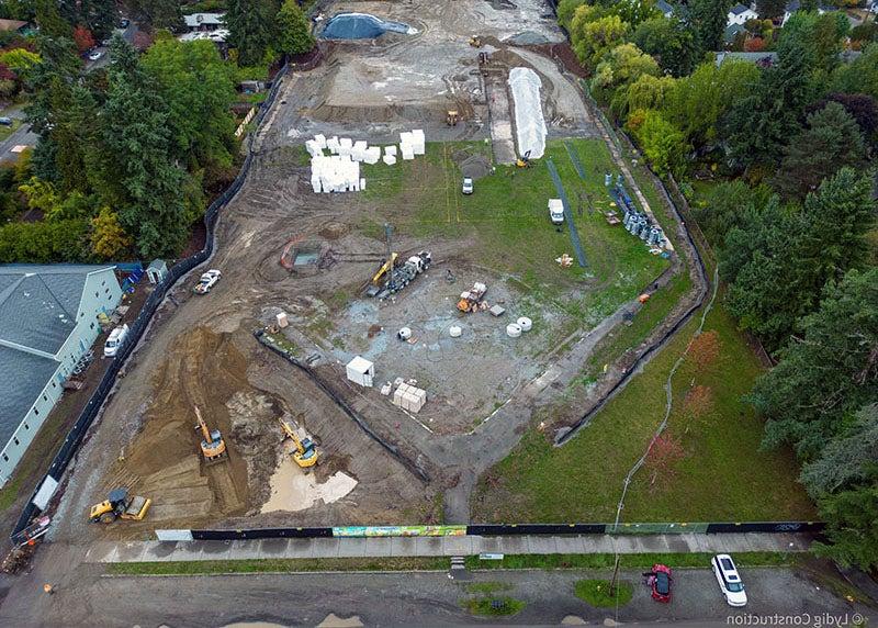 aerial view of a large construction site that has mud, grass, and equipment