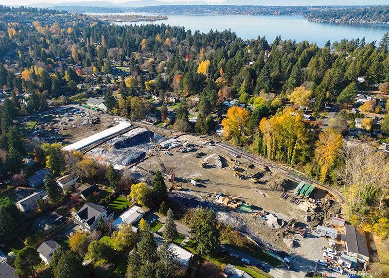 aerial view of a construction site surrounded by trees and houses