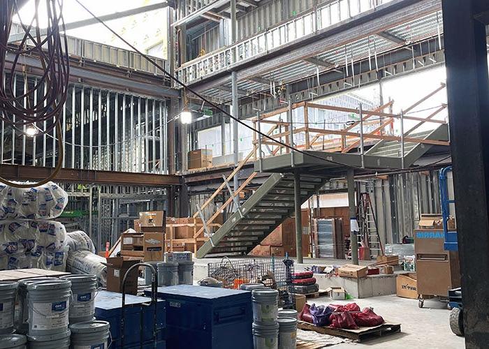 interior of a building under construction with materials on the ground floor and stairs leading up