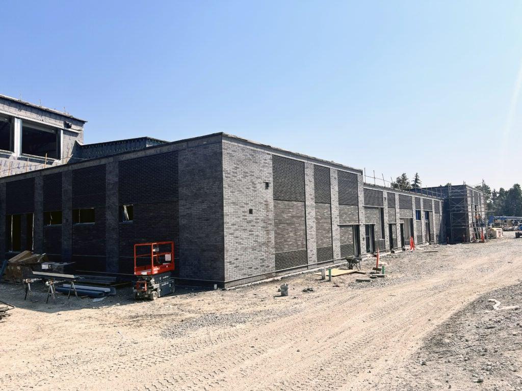 a gray brick building with dirt around it