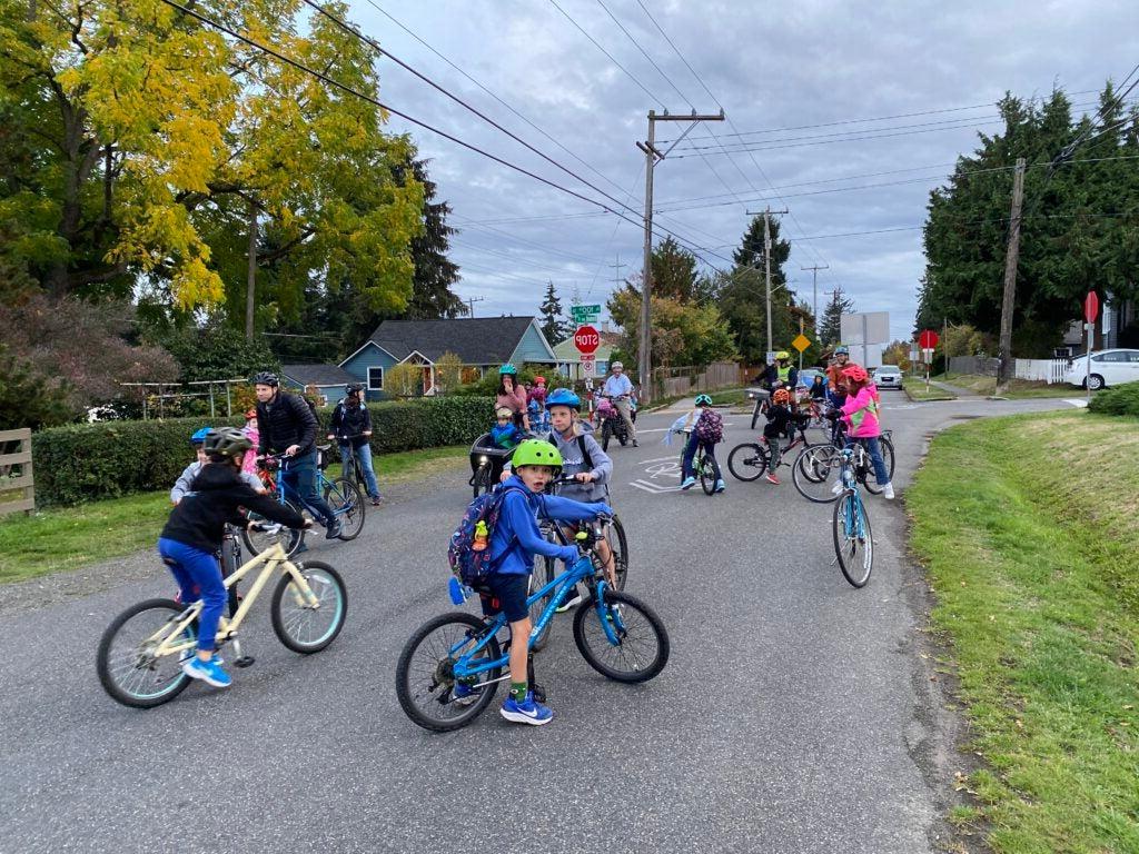 Group of student bikers on neighborhood street.