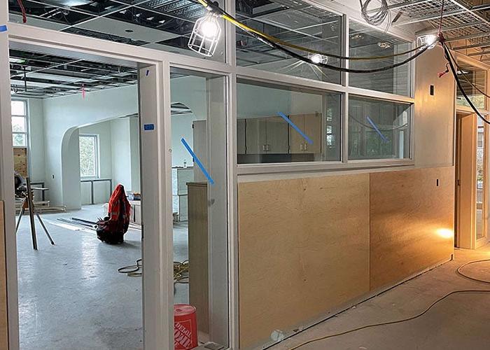 part of a hallway with a window and door leading into a classroom space