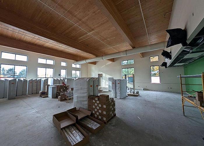 a large room under construction with a wood ceiling and one wall painted green